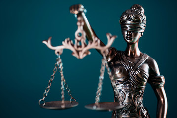 Lady justice statue scales blindfold teal background