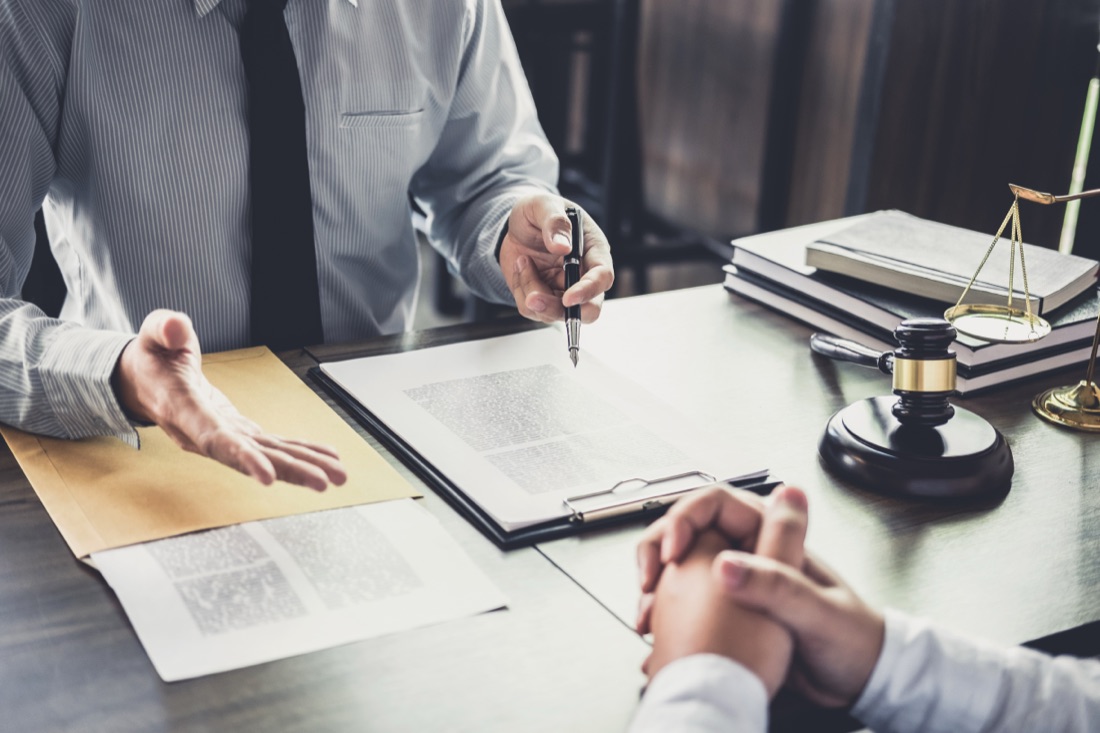 Lawyer pointing pen document signing gavel desk