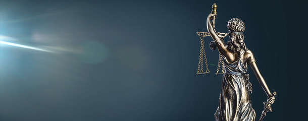 Lady justice statue scales lens flare dark blue