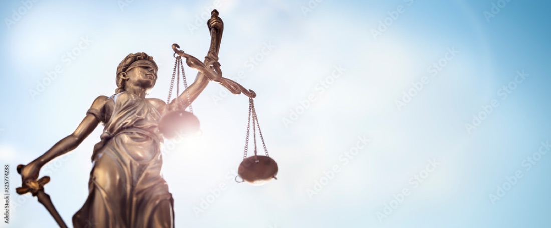 Lady justice statue balance scales sword blue sky